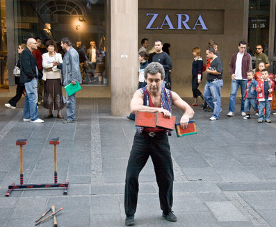 pedestrian plaza with street artists and the famous fashion store "ZARA".