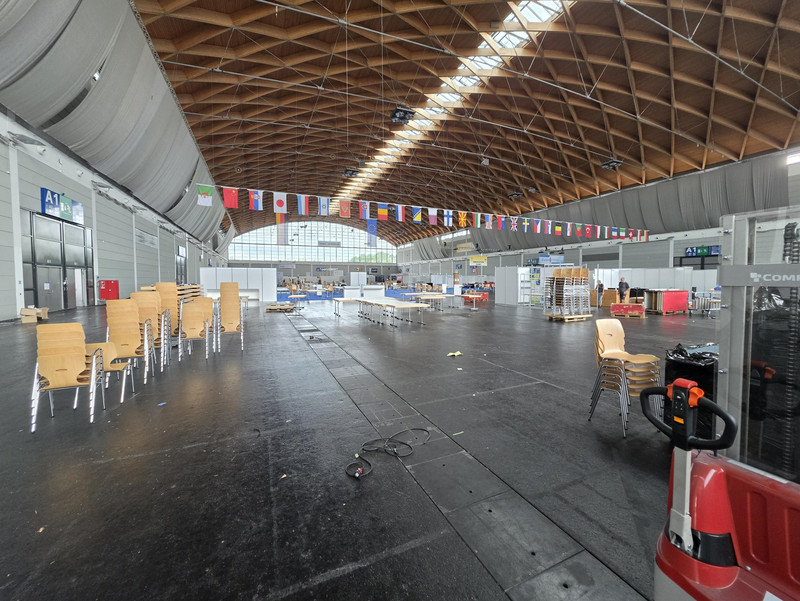 Messehalle A1 der Messe Friedrichshafen von innen, während des Abbaus der Hamradio. Man sieht gestapelte Stühle, viele Tische und halb abgebaute Messewände.