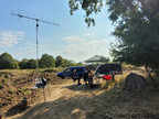 Die Fieldday-Station auf der Merscher Höhe. Im Vordergrund eine 2m-Antenne, weiter hinten der Stationstisch unter einem Sonnenschirm.